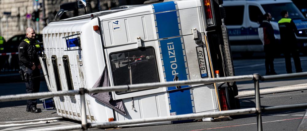 09.04.2023, Berlin: Ein umgekipptes Polizeifahrzeug liegt nach einem Unfall vor dem Bahnhof Zoo auf einer Kreuzung. Bei dem Zusammenstoß mit einem Auto wurden Autofahrer und zwei Polizisten leicht verletzt.