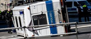 09.04.2023, Berlin: Ein umgekipptes Polizeifahrzeug liegt nach einem Unfall vor dem Bahnhof Zoo auf einer Kreuzung. Bei dem Zusammenstoß mit einem Auto wurden Autofahrer und zwei Polizisten leicht verletzt.