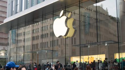 Menschen laufen vor einem Apple Store in Schanghai in China entlang. 