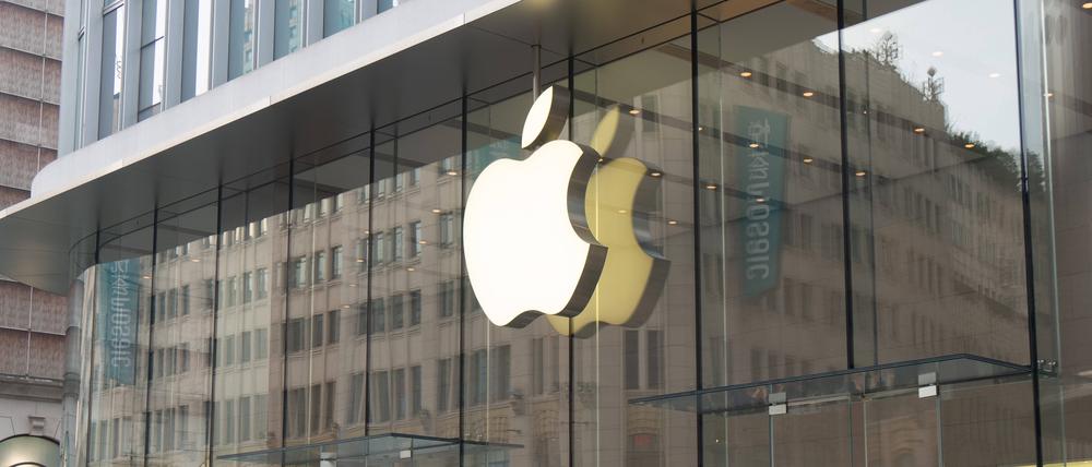 Menschen laufen vor einem Apple Store in Schanghai in China entlang. 