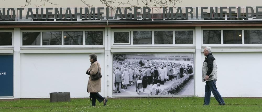 Ein Mann und eine Frau passieren in Berlin das frühere Notaufnahmelager Marienfelde. (Archivbild)