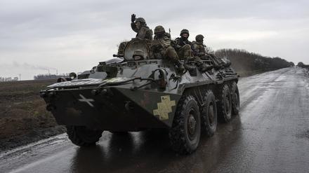 Ukrainische Soldaten fahren mit einem Schützenpanzer in Richtung Frontlinie.