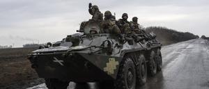 Ukrainische Soldaten fahren mit einem Schützenpanzer in Richtung Frontlinie. 