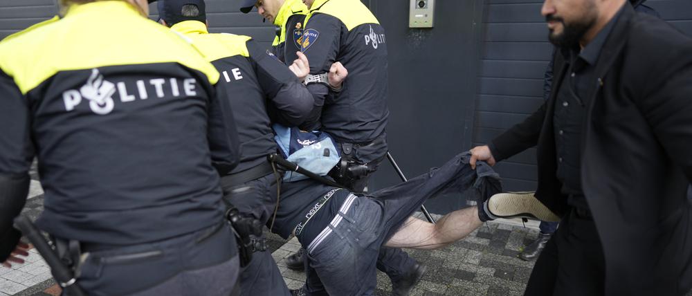 Ein Demonstrant wird von Polizisten festgehalten, als der französische Präsident Macron und der niederländische König Willem-Alexander an der naturwissenschaftlichen Fakultät der Universität von Amsterdam (UvA) eintreffen.