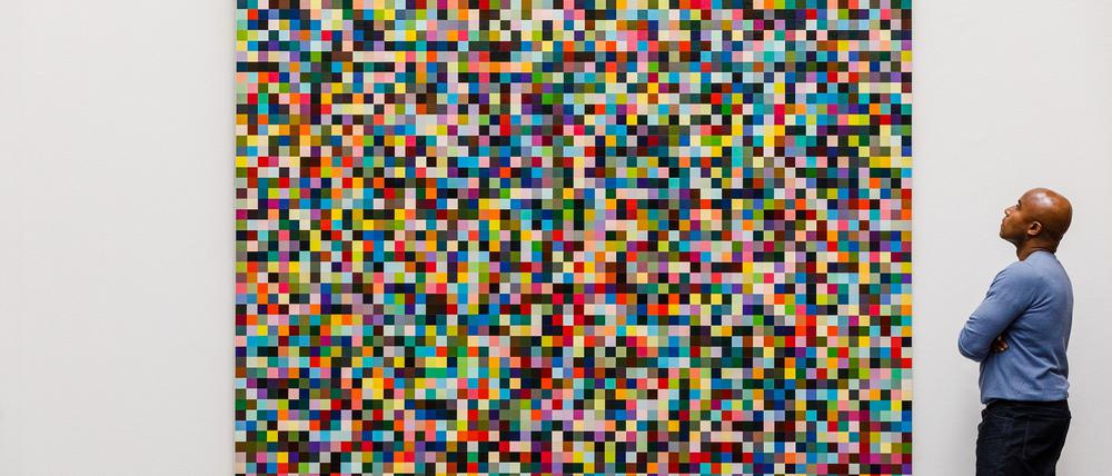 Ein Angestellter des Auktionshaus Sotheby’s betrachtet das Gemälde «4096 Farben» des deutschen Künstlers Gerhard Richter.