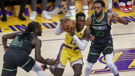 Dennis Schröder (Mitte) von den Los Angeles Lakers setzt sich gegen Mike Conley und Taurean Prince (links) von den Minnesota Timberwolves durch. 