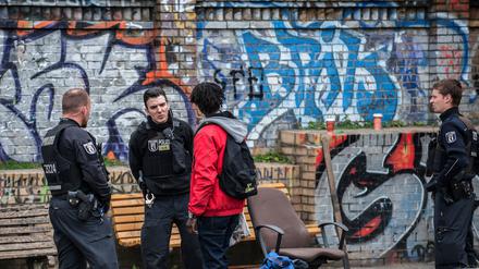 Polizisten kontrollieren einen Mann im Görlitzer Park.
