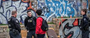 Polizisten kontrollieren einen Mann im Görlitzer Park.