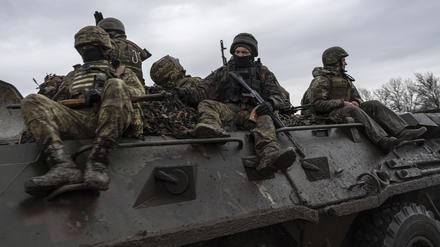 Ukrainische Soldaten fahren mit einem Schützenpanzer in Richtung Frontlinie. 
