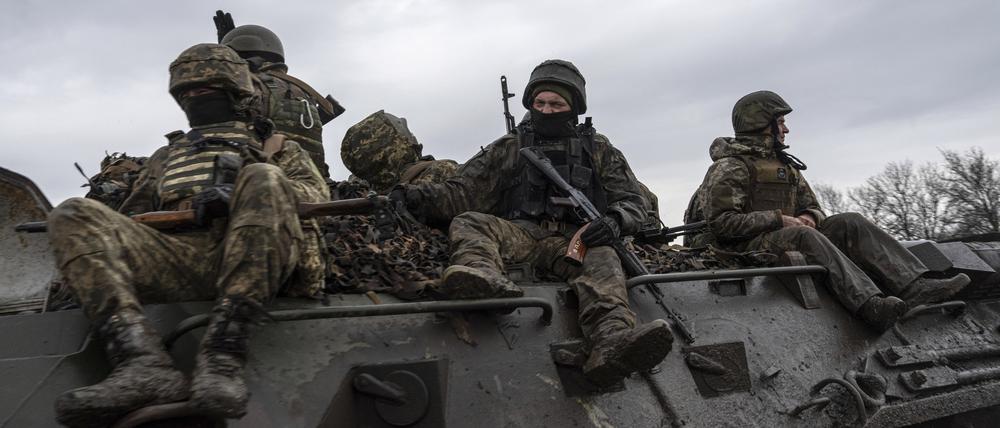 Ukrainische Soldaten fahren mit einem Schützenpanzer in Richtung Frontlinie. 