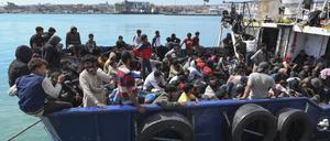 Migranten warten im sizilianischen Hafen von Catania von Bord eines Schiffes zu gehen.