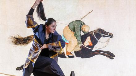 Eine Tänzerin der Gruppe Paper Tiger Theater Studio vor dem „Machang“-Bild.