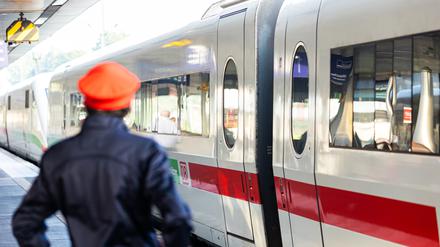 Ein Mitarbeiter der Deutschen Bahn (DB) steht neben einem ICE-Zug an einem Gleis im Hauptbahnhof Hannover.