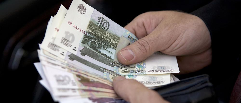 Hände mit russischen Rubel, aufgenommen am 10.06.2009 in Moskau. (Symbolbild)
