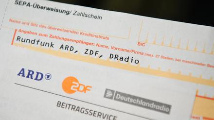 Auf einem Tisch liegt ein Anschreiben und Überweisungsträger für die Rundfunkgebühren.