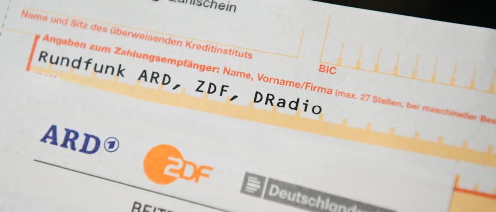 Auf einem Tisch liegt ein Anschreiben und Überweisungsträger für die Rundfunkgebühren.