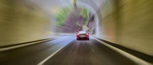 Autofahrer in Sportwagen fährt mit überhöhter Geschwindigkeit durch Tunnel.