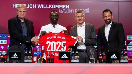 Oliver Kahn, Vorstandsvorsitzender der FC Bayern München AG, Sadio Mane, Herbert Hainer, Präsident von München, und Hasan Salihamidzic, Sportdirektor von München,(v.l.-r.) stehen nach der Vorstellung mit einem Trikot für ein Foto zusammen.