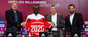 Oliver Kahn, Vorstandsvorsitzender der FC Bayern München AG, Sadio Mane, Herbert Hainer, Präsident von München, und Hasan Salihamidzic, Sportdirektor von München,(v.l.-r.) stehen nach der Vorstellung mit einem Trikot für ein Foto zusammen.