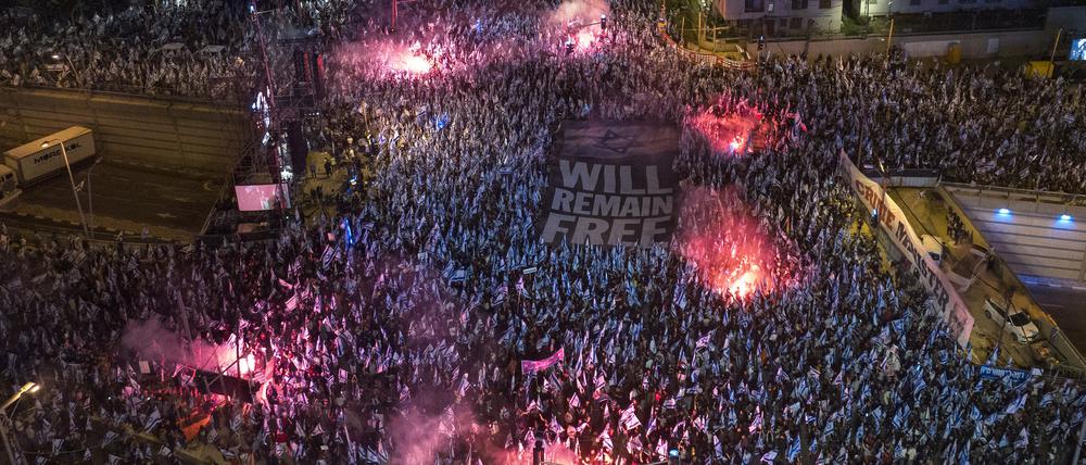 Israelis nehmen an einem Protest gegen die israelische Regierung teil und halten ein Banner auf dem «WILL REMAIN FREE» zu lesen ist. 