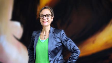Kulturamtsleiterin Birgit-Katharine Seemann vor der Kulisse einer abgespielten Inszenierung des Hans Otto Theaters in ihrem Büro.