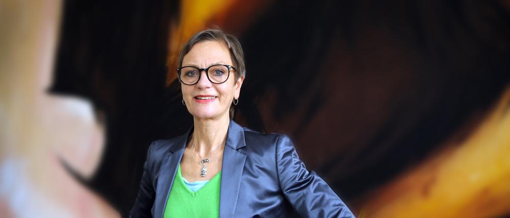Kulturamtsleiterin Birgit-Katharine Seemann vor der Kulisse einer abgespielten Inszenierung des Hans Otto Theaters in ihrem Büro.