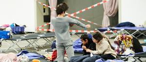 Zuhause auf Zeit: Kinder spielen auf Feldbetten in einem abgesperrten Bereich in der Messe. Dort befindet sich ein Ankunftszentrum für geflüchtete Menschen aus dem Kriegsgebiet.