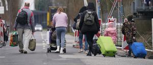 Ukrainische Flüchtlinge verlassen mit ihrem Gepäck die Flüchtlingsunterkunft im ehemaligen Fegro Großmarkt im Stadtteil Harburg.