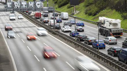 Autos fahren auf der Stadtautobahn A100, während auf der rechten Fahrbahn Autos im Stau stehen.