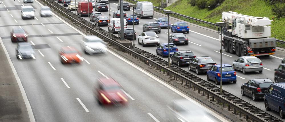 Autos fahren auf der Stadtautobahn A100, während auf der rechten Fahrbahn Autos im Stau stehen.