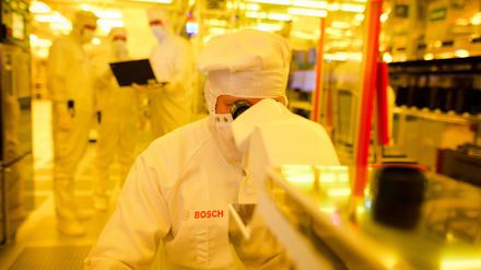 ARCHIV - Ein Mitarbeiter von Bosch kontrolliert am 16.06.2017 in einem Gelbraum eines Wafer fabs (Halbleiterwerk) in Reutlingen (Baden-Württemberg) eine Halbleiterscheibe mit einem Mikroskop auf mögliche Fehler.  (zu dpa «Bosch baut Chipfabrik in Sachsen für eine Milliarde Euro» vom 19.06.2017) Foto: Christoph Schmidt/dpa +++(c) dpa - Bildfunk+++