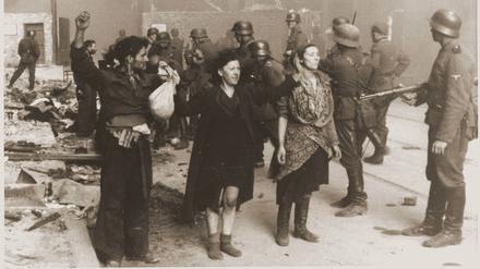 SS-Truppen bewachen Mitglieder des jüdischen Widerstands, die bei der Niederschlagung des Warschauer Ghettoaufstands 1943 gefangen genommen wurden.