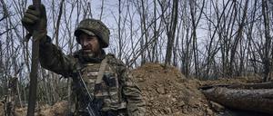Ein ukrainischer Soldat schaut aus einem Schützengraben an der Frontlinie in Bachmut. 