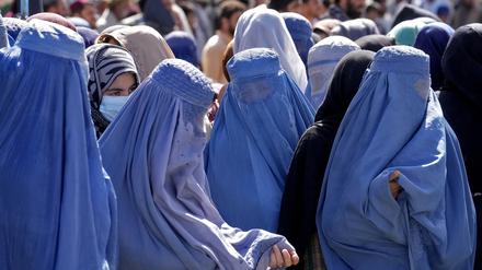In Kabul warten Frauen in Burkas auf Lebensmittelrationen.