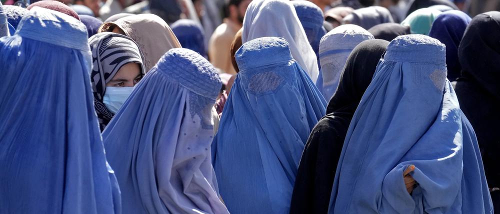 In Kabul warten Frauen in Burkas auf Lebensmittelrationen.