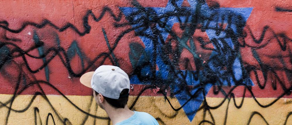 Ein junger Mann geht an dem zerstörten Wandbild des Künstlers Günther Schäfer an der East Side Gallery vorbei (Symbolbild).
