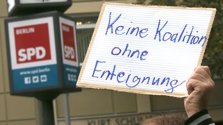 Weitere Entwicklung nach Abgeordnetenhauswahl - Ein Teilnehmer einer Demonstration hält ein Schild mit der Aufschrift "Keine Koalition ohne Enteignung" während der Sondierungsgespräche der SPD mit der CDU vor dem Kurt Schumacher Haus, der SPD-Landesgeschäftsstelle in der Müllerstraße. +++ dpa-Bildfunk +++