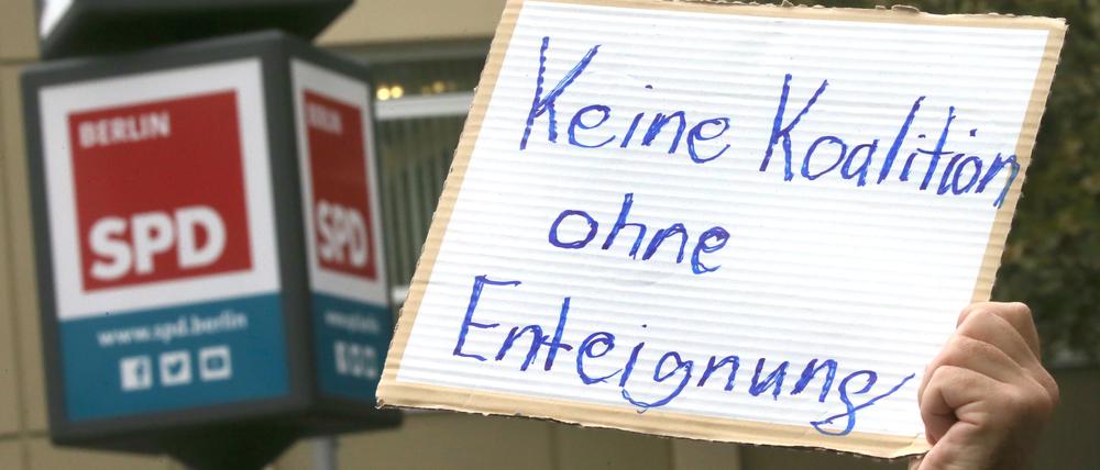Weitere Entwicklung nach Abgeordnetenhauswahl - Ein Teilnehmer einer Demonstration hält ein Schild mit der Aufschrift "Keine Koalition ohne Enteignung" während der Sondierungsgespräche der SPD mit der CDU vor dem Kurt Schumacher Haus, der SPD-Landesgeschäftsstelle in der Müllerstraße. +++ dpa-Bildfunk +++