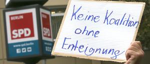 Weitere Entwicklung nach Abgeordnetenhauswahl - Ein Teilnehmer einer Demonstration hält ein Schild mit der Aufschrift "Keine Koalition ohne Enteignung" während der Sondierungsgespräche der SPD mit der CDU vor dem Kurt Schumacher Haus, der SPD-Landesgeschäftsstelle in der Müllerstraße. +++ dpa-Bildfunk +++