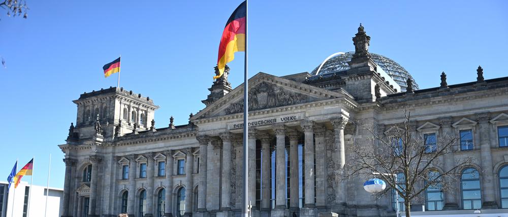 Menschen warten in einer Schlange auf den Eintritt in das Reichstagsgebäude in Berlin.