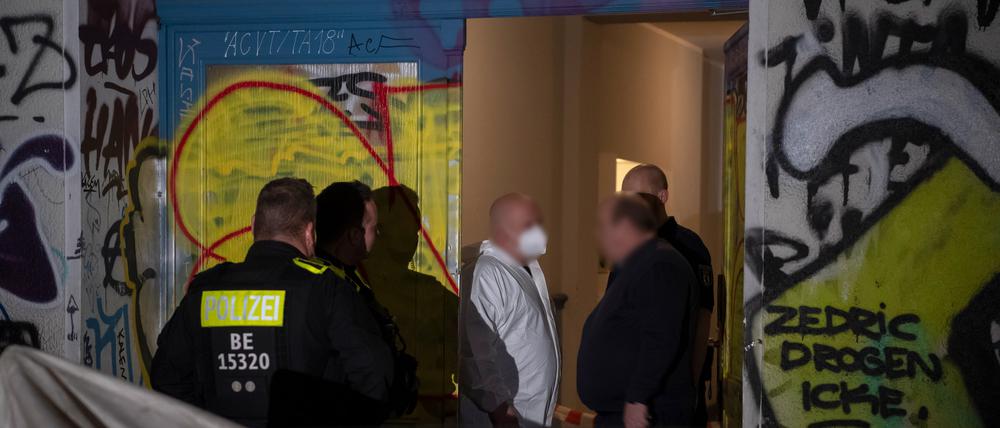 Einsatzkräfte der Polizei und der Kriminaltechnik stehen vor einem Wohnhaus. In einem Bordell in einer Wohnung in Berlin-Friedrichshain ist eine Frau getötet worden.