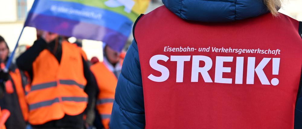 „Streik!“ steht auf der Warnweste einer Teilnehmerin am Warnstreik.