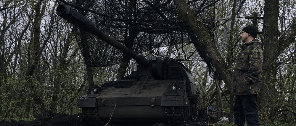 Ein ukrainischer Soldat steht neben einer deutschen Panzerhaubitze 2000, ein selbstfahrendes gepanzertes Artilleriegeschütz, in seiner Stellung an der Frontlinie..