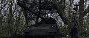 Ein ukrainischer Soldat steht neben einer deutschen Panzerhaubitze 2000, ein selbstfahrendes gepanzertes Artilleriegeschütz, in seiner Stellung an der Frontlinie..