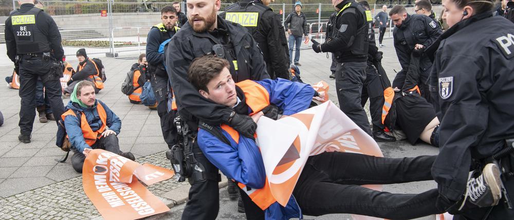 Ein Teilnehmer eines unangemeldeten Protests auf der Straße des 17. Juni in der Nähe des Brandenburger Tors wird von Polizisten weggetragen.