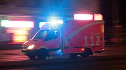 Rettungswagen der Feuerwehr während einer nächtlichen Einsatzfahrt mit Blaulicht, Symbolbild.