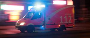 Rettungswagen der Feuerwehr während einer nächtlichen Einsatzfahrt mit Blaulicht in Berlin. (Symbolbild)