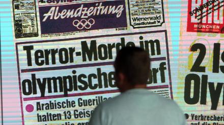 Ein Besucher betrachtet die Installation mit Titelseite und Schlagzeile der „AZ Abendzeitung“ über den Mordanschlag am Erinnerungsort an das Olympia-Attentat vom 05. September 1972.