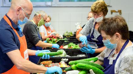 Helfer sortieren vor Beginn der Ausgabe bei der Potsdamer Tafel die Lebensmittel-Spenden aus den Supermärkten.