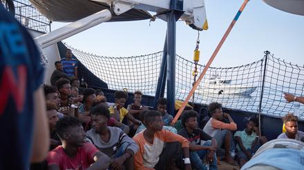 Die von der Seenotrettungsorganisation Sea-Eye herausgegebene Aufnahme zeigt Flüchtlinge an Bord des Seenotrettungsschiffs „Alan Kurdi“ während ein Boot der italienischen Guardia di Finanza vorbei fährt.